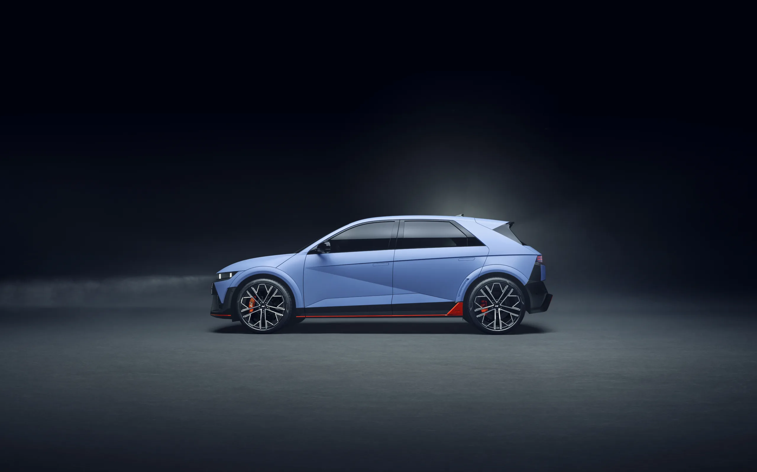 Side profile of the Hyundai Ioniq 5 N in blue, featuring sharp lines and high-performance wheels against a dark background